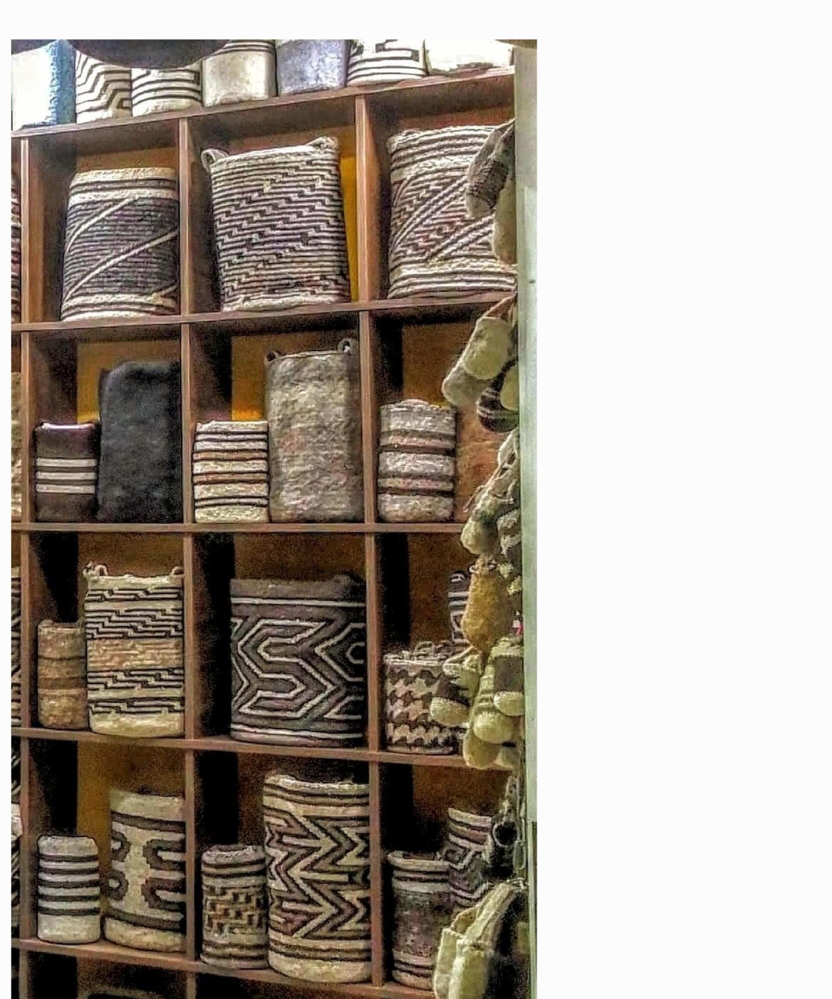 Colorful mochilas woven by Arhuaco women displayed in cubbies